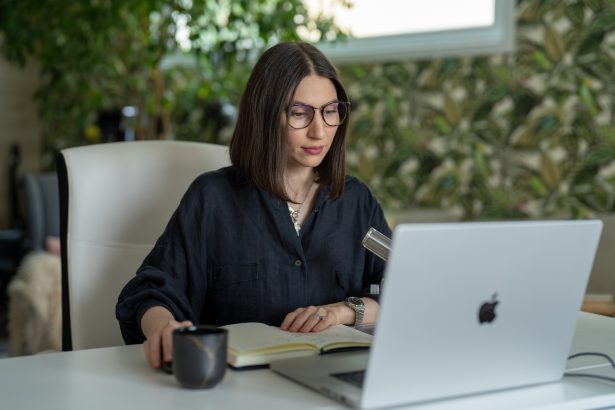 a person sitting at a table with a laptop