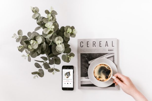 flat lay photography of smartphone, newspaper, and teacup