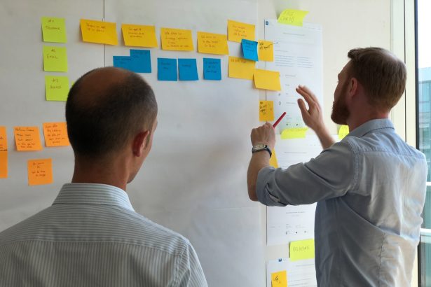 man in gray shirt facing sticky notes